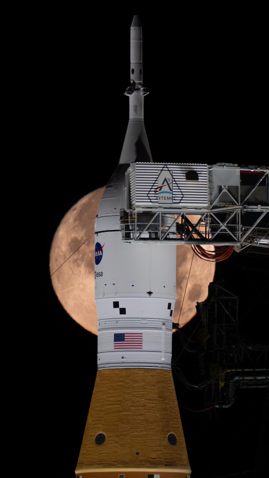 A full Moon is seen setting behind NASA’s SLS (Space Launch System) and Orion spacecraft, atop the mobile launcher in the early hours of February 1, 2026. The rocket is currently at Launch Pad 39B at NASA’s Kennedy Space Center in Florida, as teams are preparing for a wet dress rehearsal to practice timelines and procedures for the launch of Artemis II.
